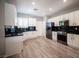 Spacious kitchen with white cabinets, black subway tile backsplash, stainless steel appliances, and wood-look floors at 2545 Divine Sky Dr, Henderson, NV 89044