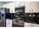Modern kitchen featuring stainless steel appliances, black countertops, and white cabinetry at 2545 Divine Sky Dr, Henderson, NV 89044