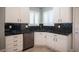 Modern kitchen featuring black subway tile backsplash, black counters, stainless steel appliances, and white cabinets at 2545 Divine Sky Dr, Henderson, NV 89044