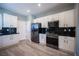 Modern kitchen with stainless steel appliances, dark granite countertops, and sleek white cabinetry at 2545 Divine Sky Dr, Henderson, NV 89044