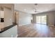 Open floor plan with wood-look flooring, a ceiling fan, and sliding glass doors leading to the backyard at 2545 Divine Sky Dr, Henderson, NV 89044