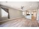 Living room with wood-look flooring, ceiling fan, and an open floor plan with kitchen access at 2545 Divine Sky Dr, Henderson, NV 89044