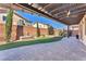 Paver-lined backyard featuring artificial grass, a Buddha fountain, and a pergola for shade at 261 Via Morelli, Henderson, NV 89011
