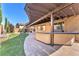 Paver patio with a pergola, an outdoor bar, and landscaped lawn, perfect for outdoor entertaining at 261 Via Morelli, Henderson, NV 89011