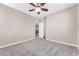 Neutral bedroom featuring plush gray carpet, modern ceiling fan and access to upstairs landing at 261 Via Morelli, Henderson, NV 89011
