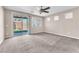 Carpeted bedroom with sliding glass doors leading to the backyard and many windows at 261 Via Morelli, Henderson, NV 89011