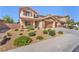 Inviting two-story home featuring desert landscaping, a two-car garage, and a charming stucco facade at 261 Via Morelli, Henderson, NV 89011