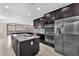 Modern kitchen boasting stainless steel appliances, a center island, and dark cabinetry at 261 Via Morelli, Henderson, NV 89011