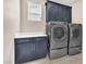 Functional laundry room with gray cabinets, white countertop, and stainless steel washer and dryer at 261 Via Morelli, Henderson, NV 89011