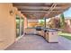 Outdoor kitchen with a built-in grill and stainless steel appliances, under a stylish pergola at 261 Via Morelli, Henderson, NV 89011