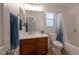 Bright bathroom featuring a modern vanity, bathtub with shower, and a window providing natural light at 2640 Torch Ave, North Las Vegas, NV 89081
