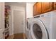 Functional laundry room with modern washer and dryer, plus storage shelves and cabinets at 2640 Torch Ave, North Las Vegas, NV 89081