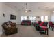 Comfortable living area with plush seating, ceiling fan, and plenty of natural light from large windows at 2640 Torch Ave, North Las Vegas, NV 89081