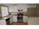 Galley kitchen features granite countertops, white cabinetry, and stainless steel appliances at 2777 Beaconfalls Way, Las Vegas, NV 89142