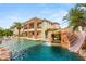 Resort-style backyard pool with slide, waterfalls, mature palm trees, and lush landscaping at 2793 Red Arrow Dr, Las Vegas, NV 89135