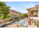 Luxury home featuring a large pool, waterfall and spa with stunning views of the desert landscape at 2793 Red Arrow Dr, Las Vegas, NV 89135