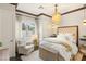 Bright bedroom features a tufted headboard, chandelier, seating area, and views of the yard at 2793 Red Arrow Dr, Las Vegas, NV 89135