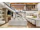 Expansive living room with soaring ceilings, wooden beams, grand staircase, chef's kitchen, and floor-to-ceiling stone fireplace at 2793 Red Arrow Dr, Las Vegas, NV 89135