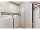 Functional laundry room featuring a washer, dryer, and storage cabinets at 2857 San Lago Ct, Las Vegas, NV 89121