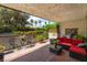 Inviting covered patio with outdoor seating and lush green landscaping at 2857 San Lago Ct, Las Vegas, NV 89121