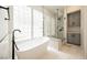 Elegant bathroom featuring a soaking tub, glass shower, and gray cabinetries at 3042 Soft Horizon Way, Las Vegas, NV 89135