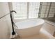 Modern bathroom featuring a sleek, standalone tub and stylish black fixtures at 3042 Soft Horizon Way, Las Vegas, NV 89135