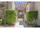 Charming front entrance featuring a stone facade, decorative shrubs, and an inviting wrought iron gate at 3042 Soft Horizon Way, Las Vegas, NV 89135