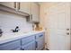 Laundry room featuring a utility sink and light gray cabinets at 3042 Soft Horizon Way, Las Vegas, NV 89135