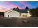 Charming single-story home with a three-car garage at sunset with desert landscaping at 3580 S Shawnee Ave, Pahrump, NV 89048