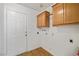 Bright laundry room with wooden cabinets and durable wood-look flooring at 3580 S Shawnee Ave, Pahrump, NV 89048