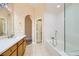 Bathroom featuring tile floors, dual sinks, and a bathtub with a glass enclosure at 3640 Snowy Pines St, Las Vegas, NV 89147