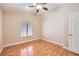 Cozy bedroom with wood floors, a ceiling fan, and a window with blinds for natural light at 3640 Snowy Pines St, Las Vegas, NV 89147