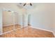 Spacious bedroom with hardwood floors, mirrored closet doors, and a ceiling fan at 3640 Snowy Pines St, Las Vegas, NV 89147