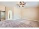 Large carpeted primary bedroom with a ceiling fan, arched doorway, and ample space at 3640 Snowy Pines St, Las Vegas, NV 89147