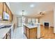 Open-concept kitchen flowing into the living area, featuring white countertops and wood cabinets at 3640 Snowy Pines St, Las Vegas, NV 89147