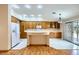 Bright kitchen featuring a center island, wood cabinetry, and a sliding glass door leading to the backyard at 3640 Snowy Pines St, Las Vegas, NV 89147