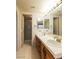 Dual sink bathroom with tiled countertop, large mirror, and walk-in shower at 390 Montego Ln, Boulder City, NV 89005