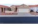 Single-story home with a two-car garage, desert landscaping, and a tile roof for a classic Southwest aesthetic at 390 Montego Ln, Boulder City, NV 89005