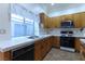 Bright kitchen features tiled counters, light wood cabinets, and stainless sink at 390 Montego Ln, Boulder City, NV 89005