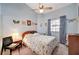 Bright bedroom showcasing blue walls, a ceiling fan, and a comfortable floral patterned bed at 3987 Saddlewood Ct, Las Vegas, NV 89121