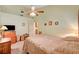 This bedroom features a ceiling fan, a warm color palette, and matching wooden furniture at 3987 Saddlewood Ct, Las Vegas, NV 89121