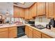 Well-lit kitchen featuring oak cabinets and tile countertops plus a black stove and dishwasher at 3987 Saddlewood Ct, Las Vegas, NV 89121