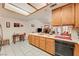Kitchen showcases light wood cabinets, tiled flooring and countertops, and a view into the living space at 3987 Saddlewood Ct, Las Vegas, NV 89121