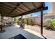 Covered patio area featuring a grill, brick accents, and ample space for outdoor dining and entertaining at 3987 Saddlewood Ct, Las Vegas, NV 89121