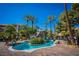 Beautiful community pool with rock waterfall feature surrounded by lush landscaping and deck chairs at 4200 S Valley View Blvd # 1077, Las Vegas, NV 89103