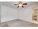 Bedroom featuring neutral carpet, a ceiling fan, and a glimpse of the bathroom at 445 Intrepid Ct, Boulder City, NV 89005