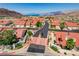 This is an aerial view of a neighborhood with red tiled roofs near mountains and a lake in the distance at 445 Intrepid Ct, Boulder City, NV 89005