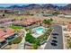 This aerial shot showcases a luxurious community pool, lush landscaping, and desert mountain views at 445 Intrepid Ct, Boulder City, NV 89005