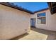 View of the stucco exterior with light-blue front door and windows allowing natural light into the home at 445 Intrepid Ct, Boulder City, NV 89005
