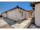 Exterior view showcasing the side of the townhome with a two-car garage, tile roof and gated entryway at 445 Intrepid Ct, Boulder City, NV 89005